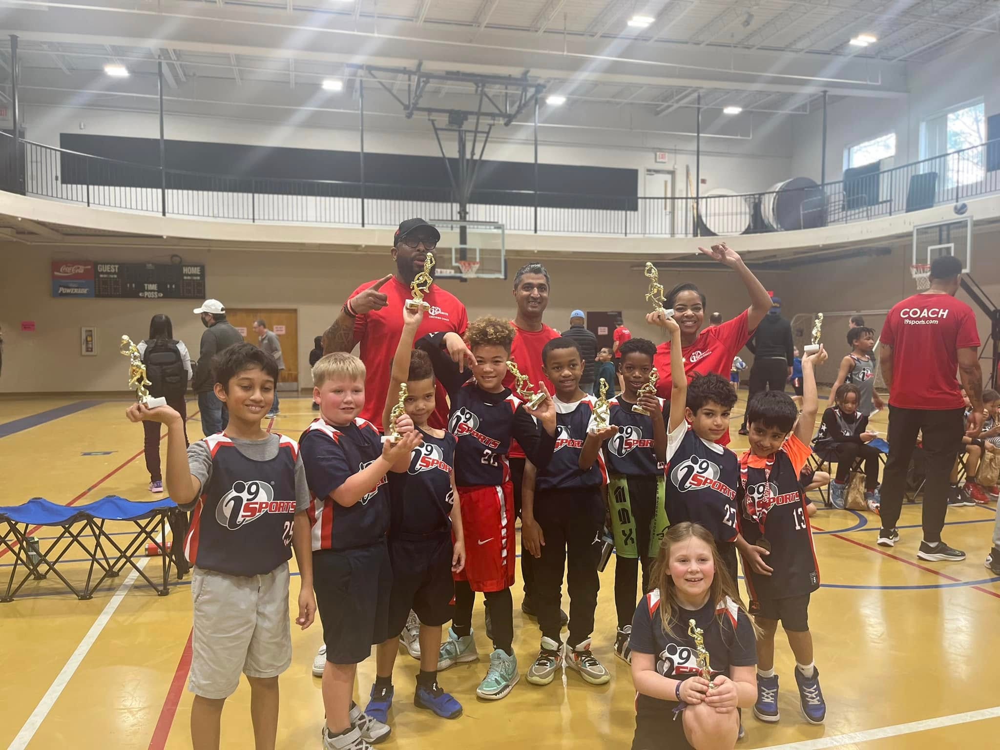 Jean-Paul Waterford with full i9 Sports basketball team holding trophies